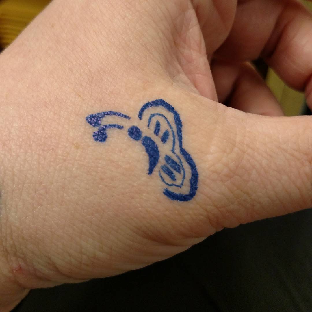 Simple blue semicolon butterfly tattoo on the hand carries a message of hope, resilience, and embracing one's journey