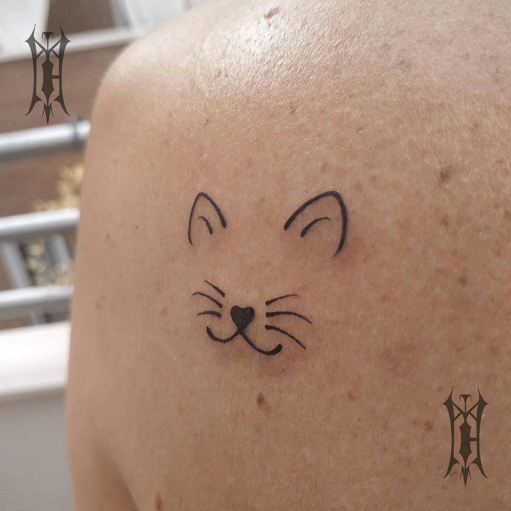 Simple cat face tattoo on a shoulder