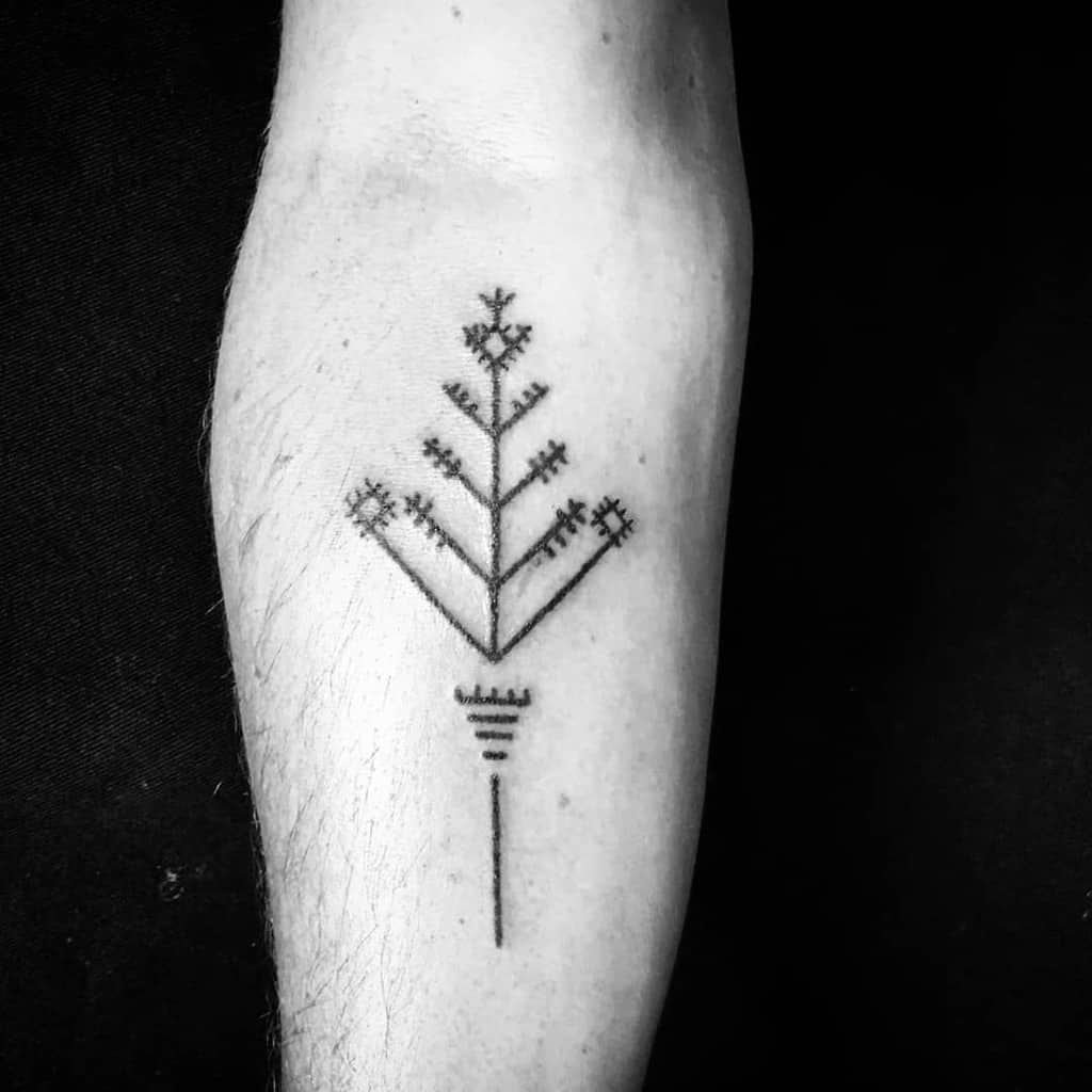 Black geometric tree tattoo on a forearm