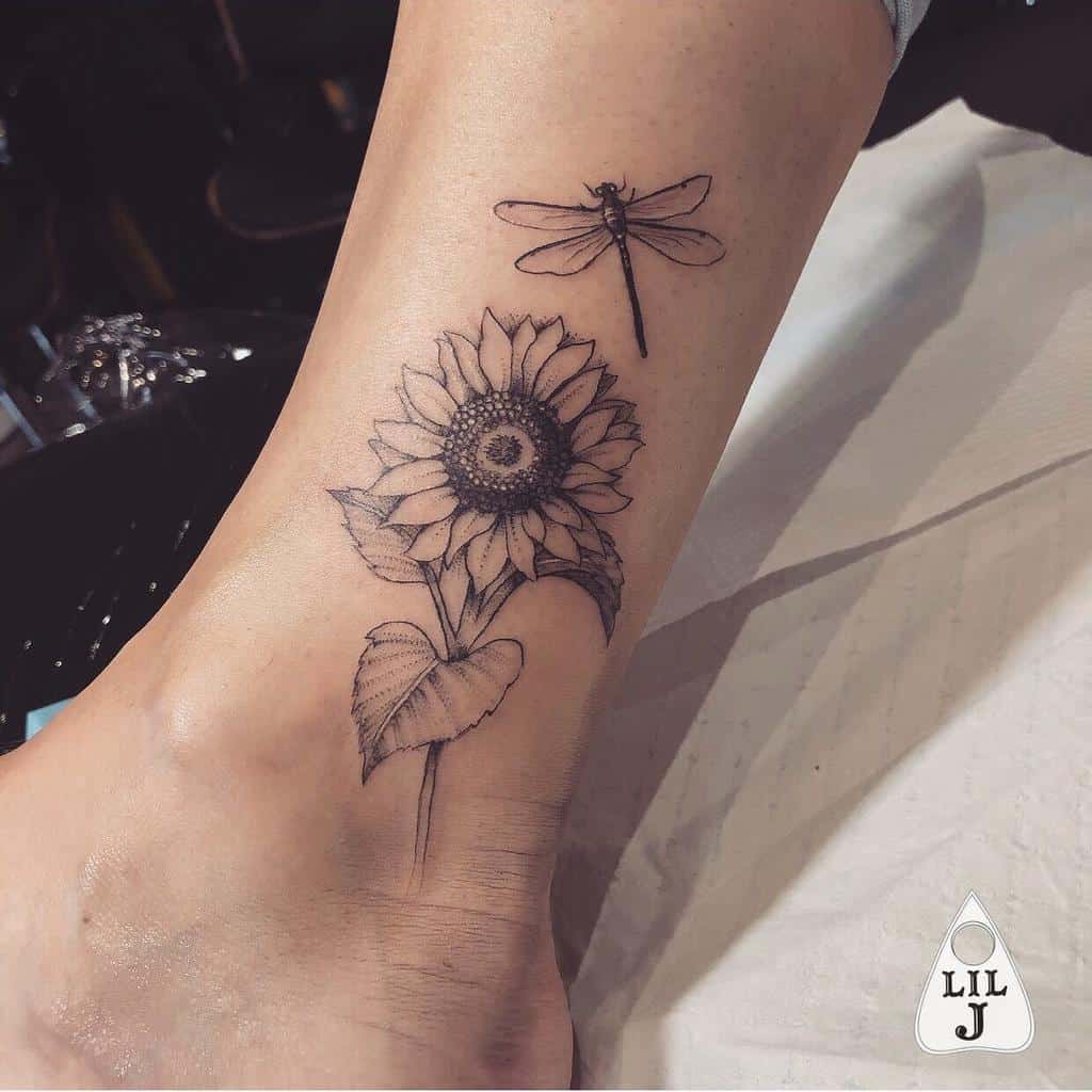 Tattoo of a sunflower and dragonfly on an ankle