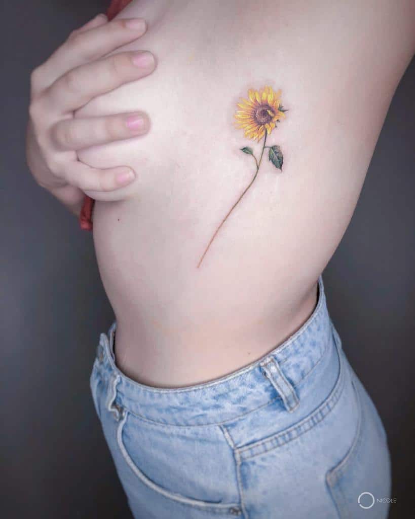 Side view of a torso with a sunflower tattoo