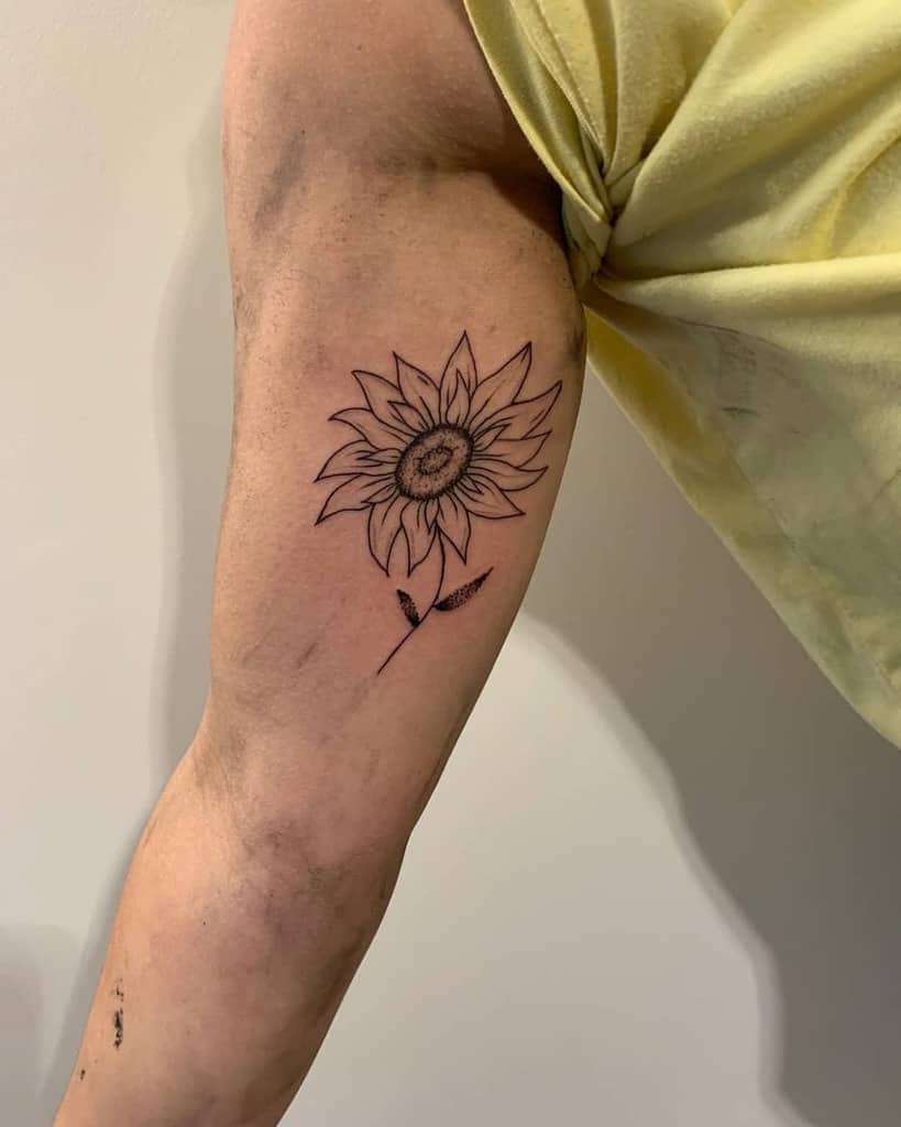 Line art sunflower tattoo on an arm