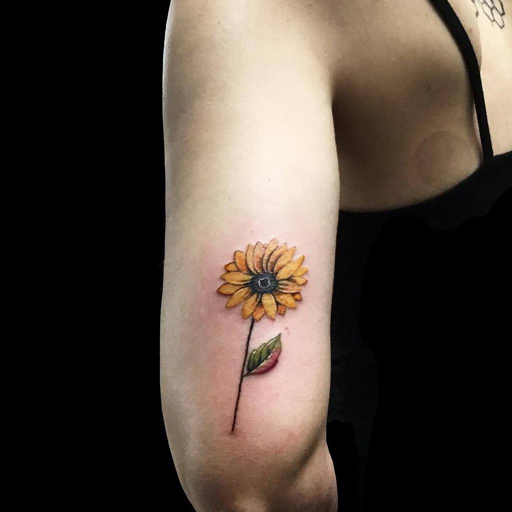 Tattoo of a sunflower on a person's upper arm