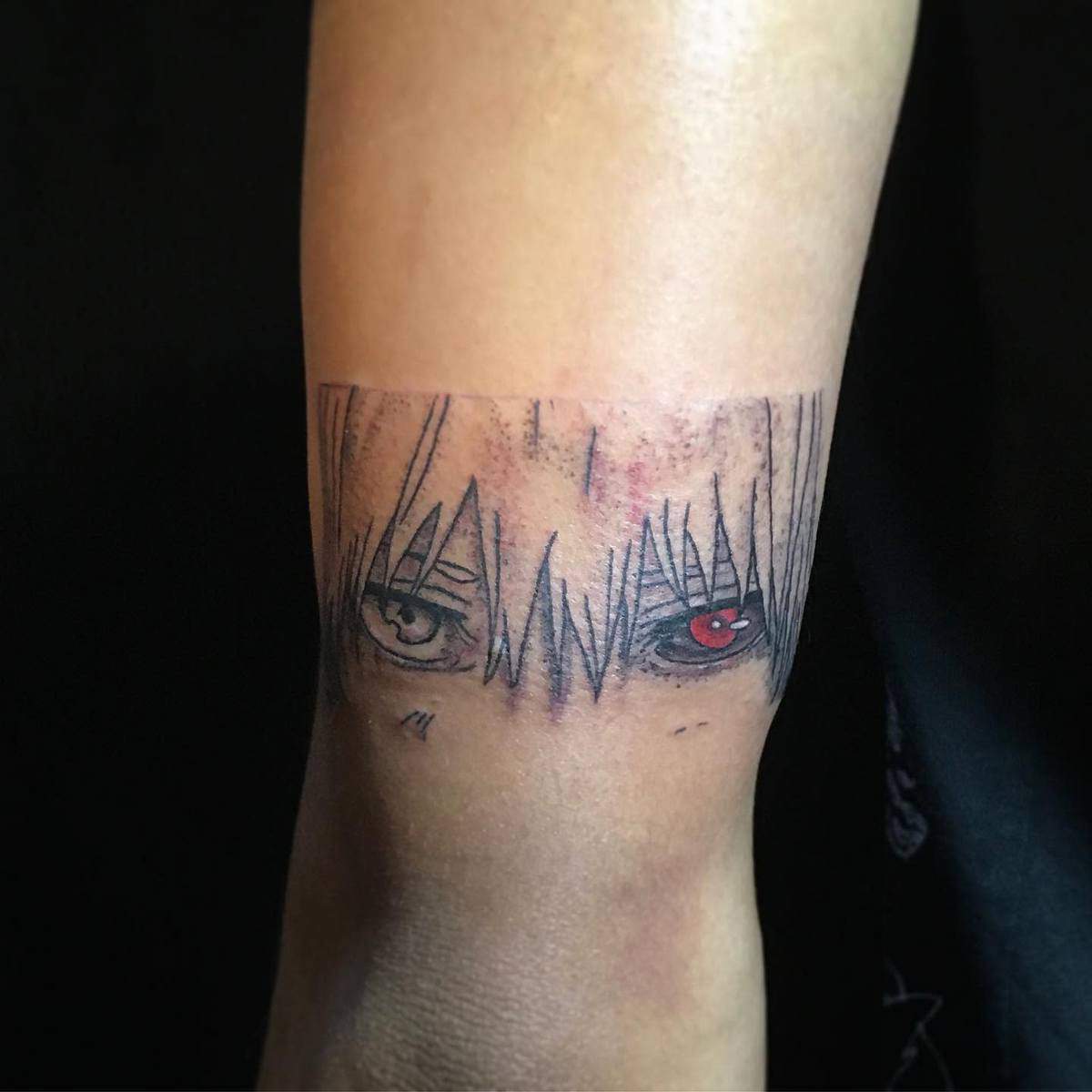 Small arm tattoo featuring Kaneki Ken's intense eyes from Tokyo Ghoul, highlighting his ghoul eye in red