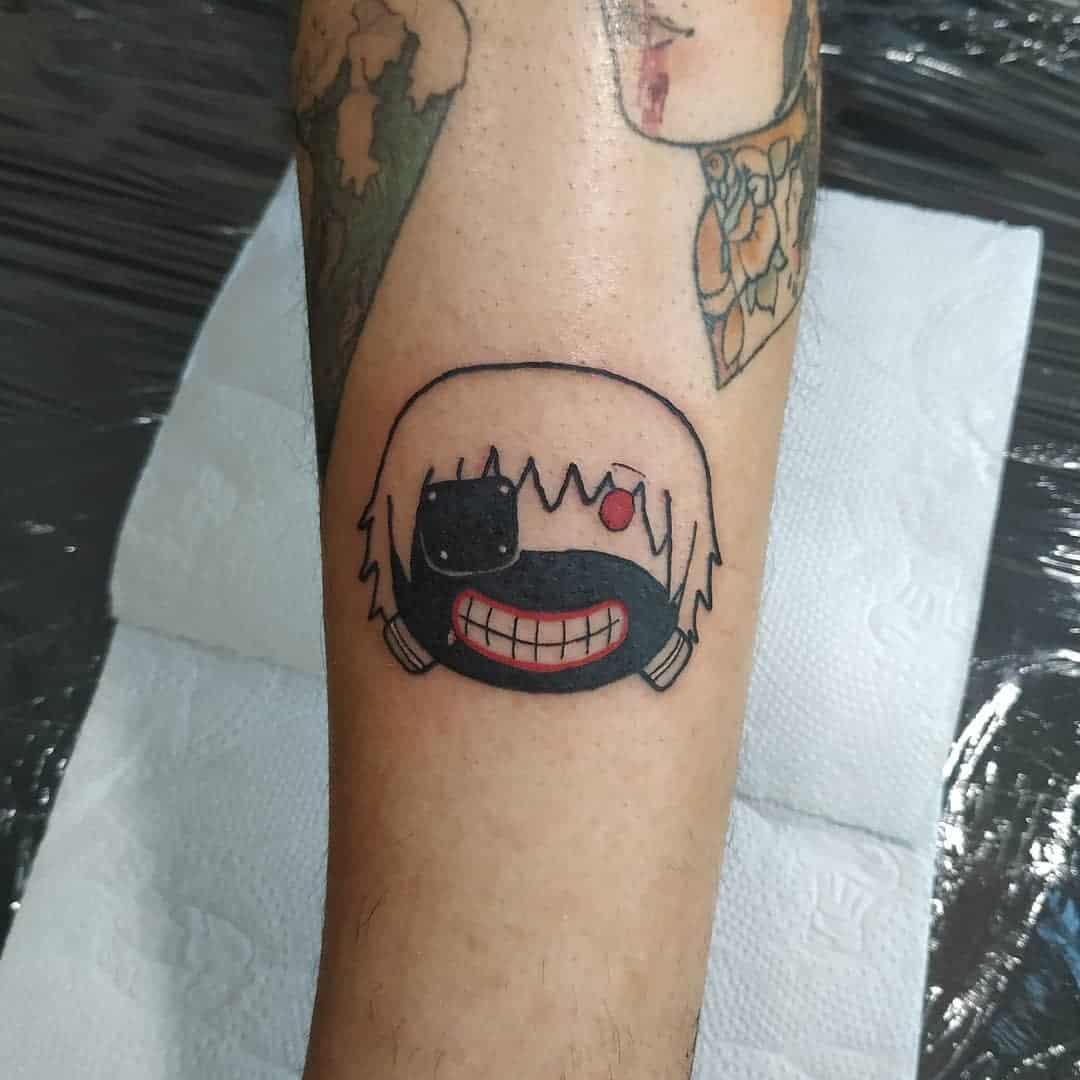 Small, stylized tattoo of Kaneki Ken from Tokyo Ghoul, featuring his masked face with a cute, simplified design