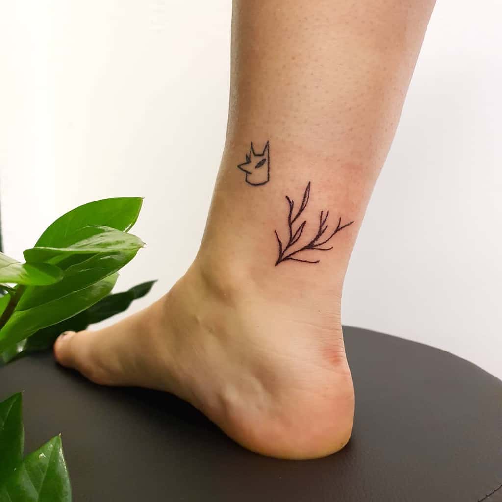 Ankle tattoo of a delicate branch with leaves