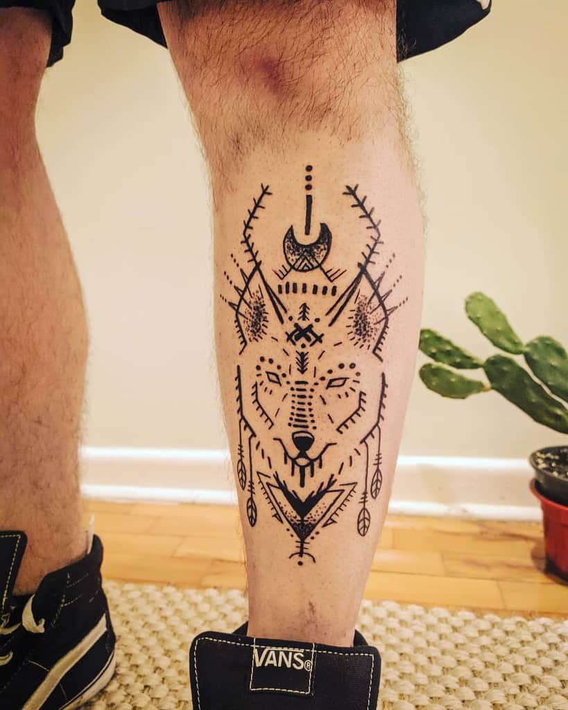 Geometric wolf tattoo with a tribal flair graces the man's leg