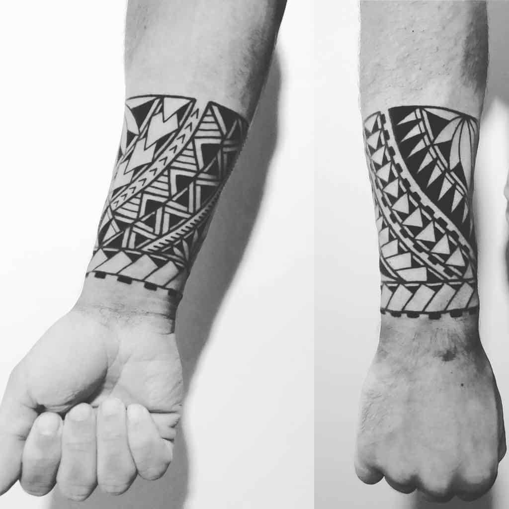 A striking black geometric tattoo adorns the forearm, intricately interwoven with tribal patterns and shapes