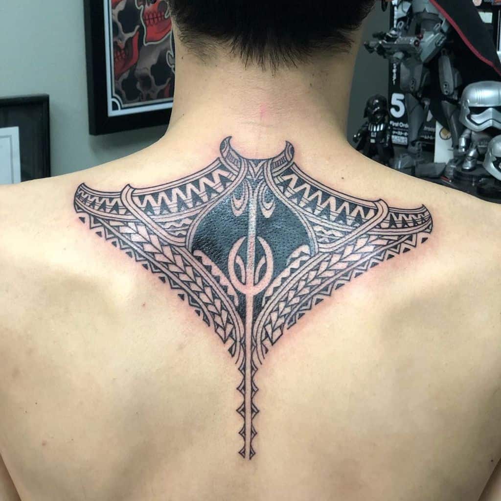 An intricate tribal tattoo graces the person's upper back, weaving traditional patterns into a stunning display of art
