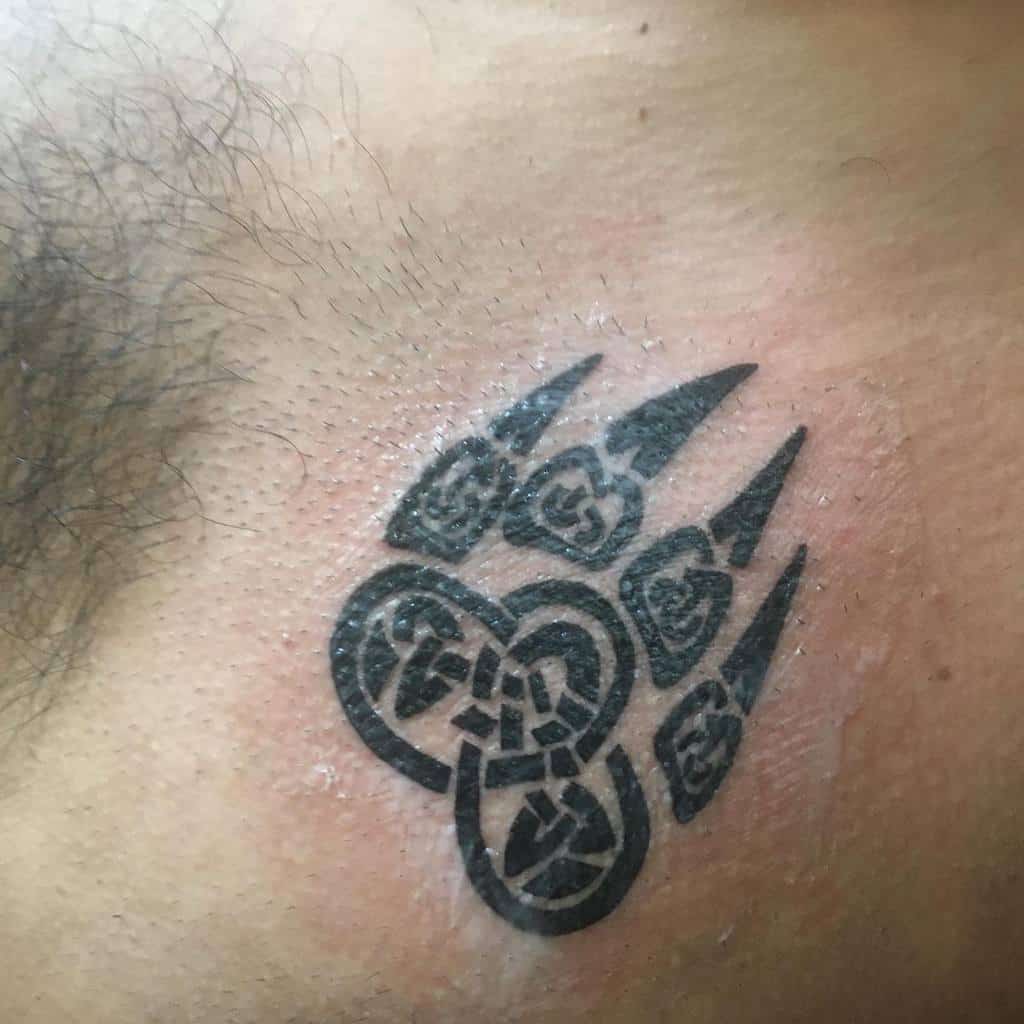 Bear-inspired paw tattoo with intricate tribal designs on skin