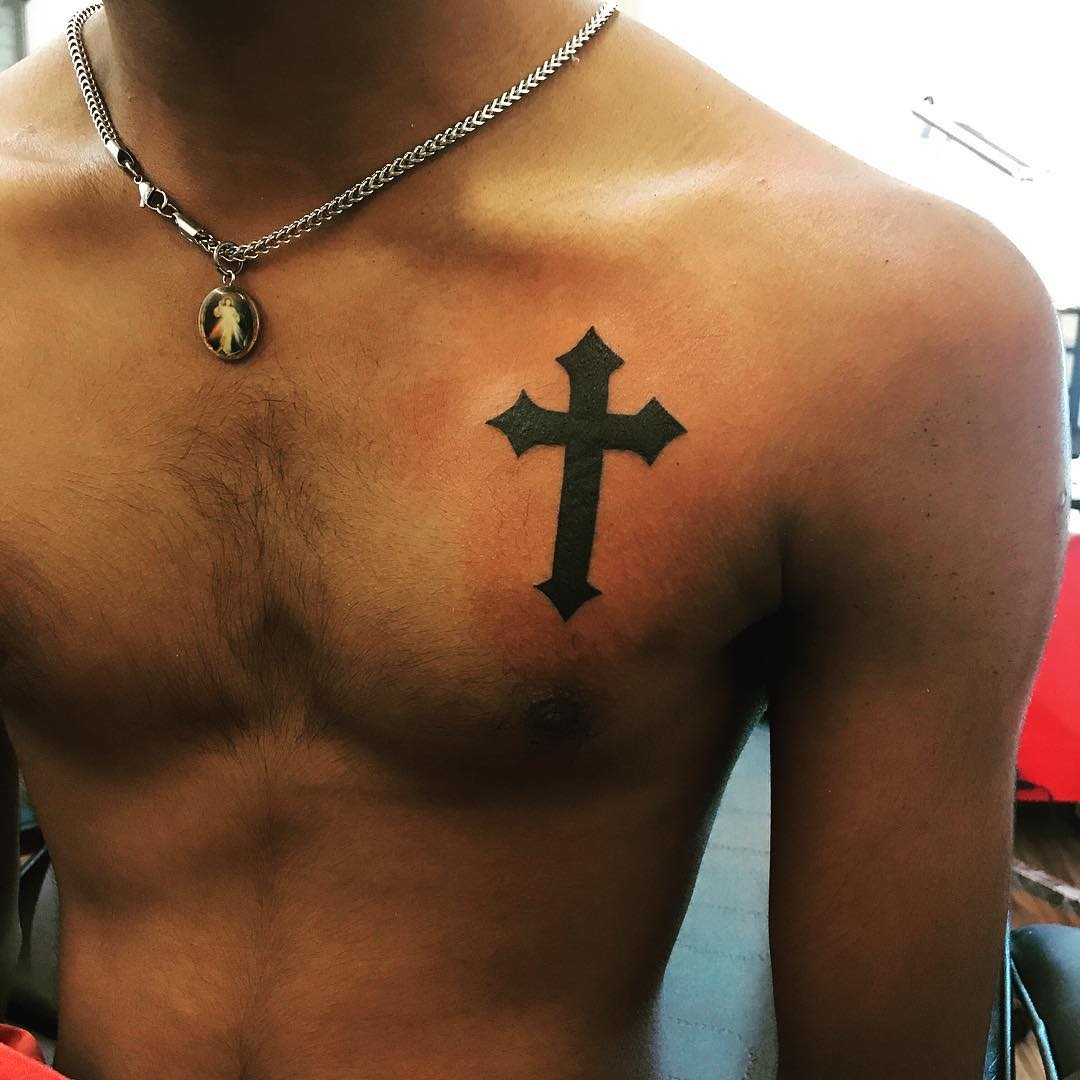 Small Tribal Cross Tattoo on Man's Chest