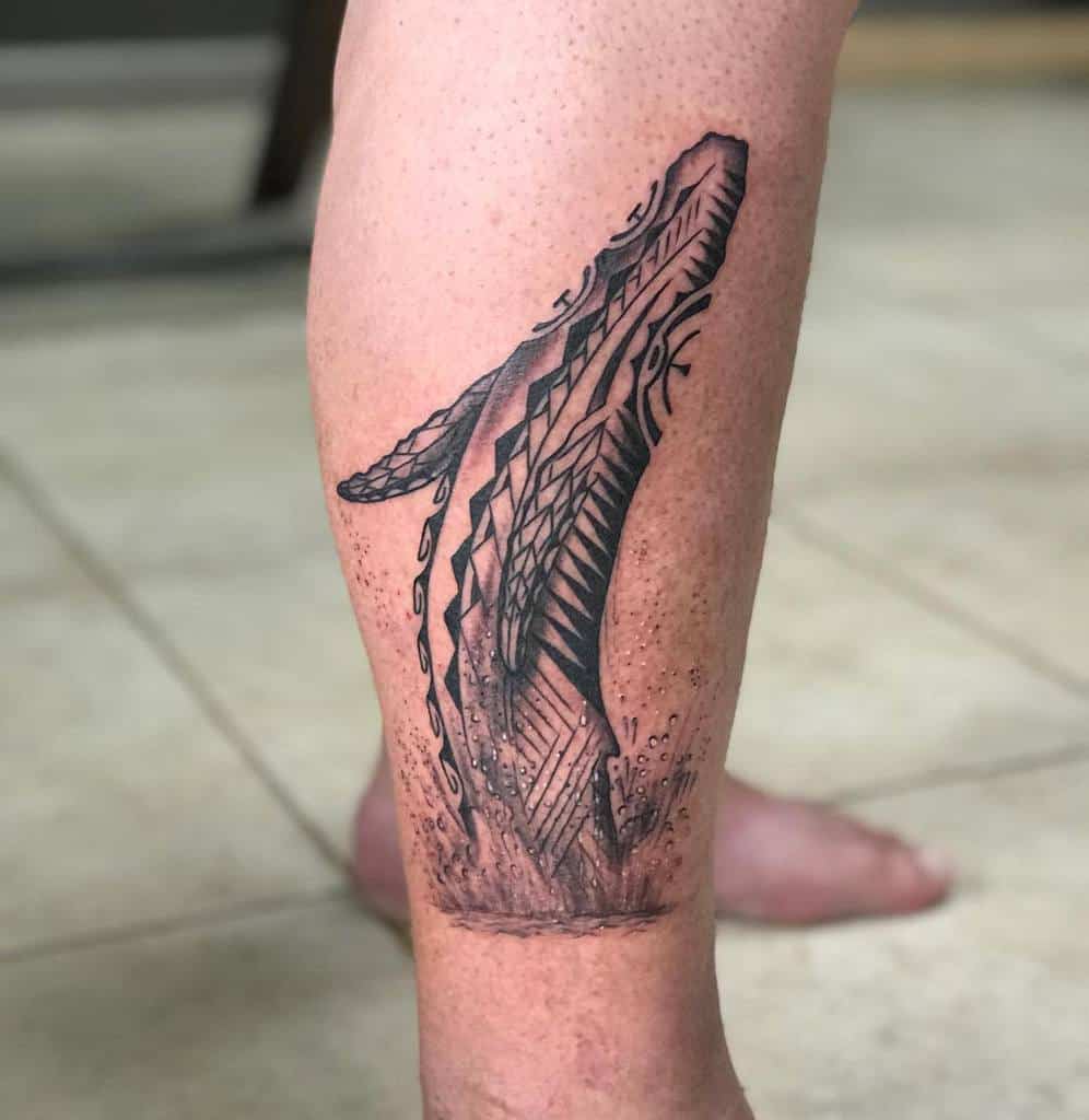 Tattoo of a stylized, tribal whale breaching on a calf