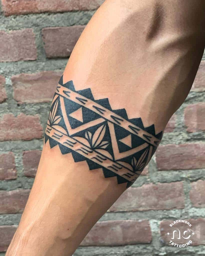 A tattooed arm showcases a tribal-style black band