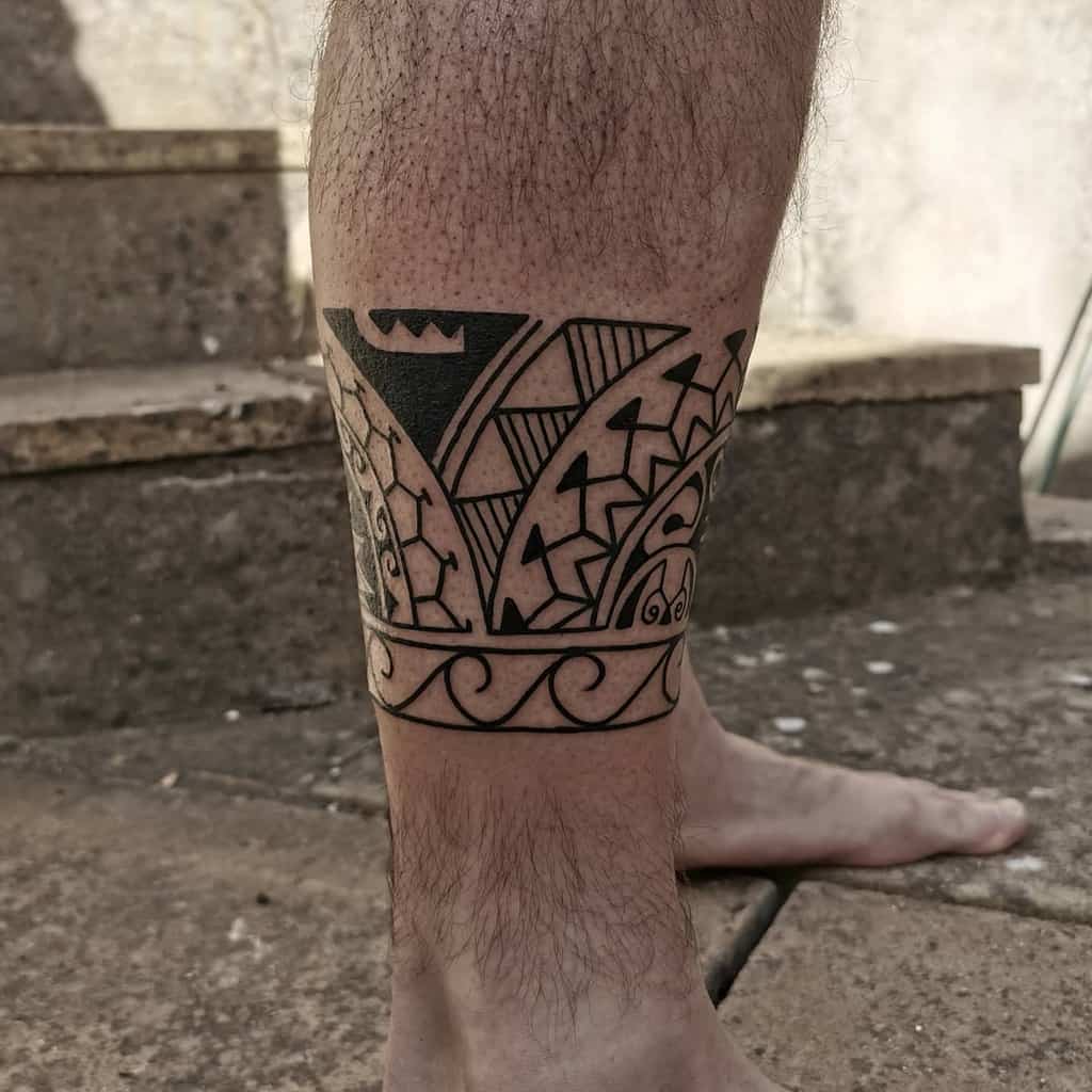The tattoo features a bold Polynesian design on the calf, with intricate geometric shapes, sharp lines, and a mix of solid black and patterned details, creating a dynamic and balanced composition