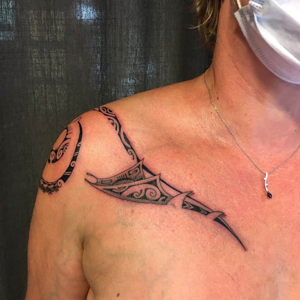 Person with tribal-style shoulder and chest tattoo