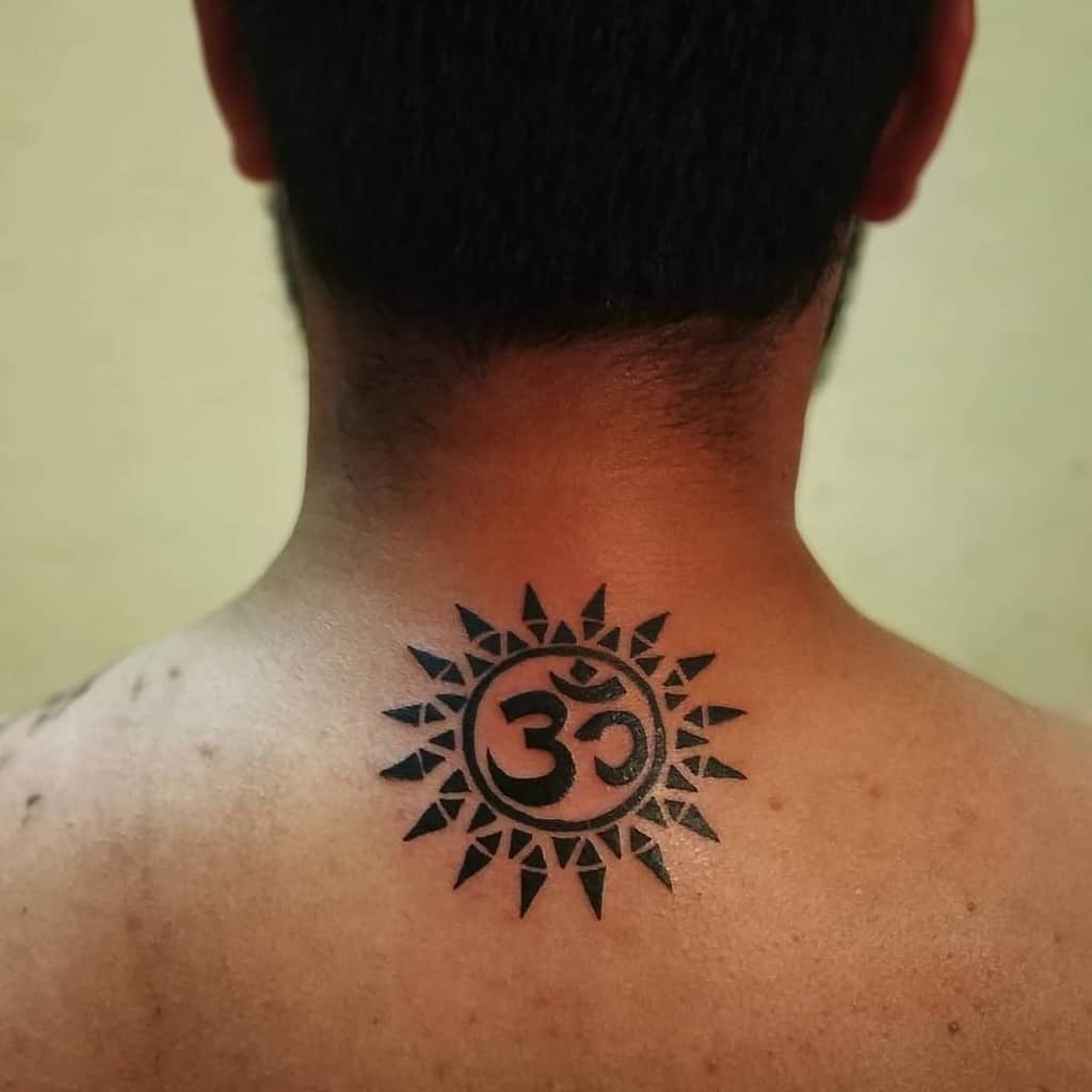 Back tattoo featuring a tribal sun design with the Om symbol in the center