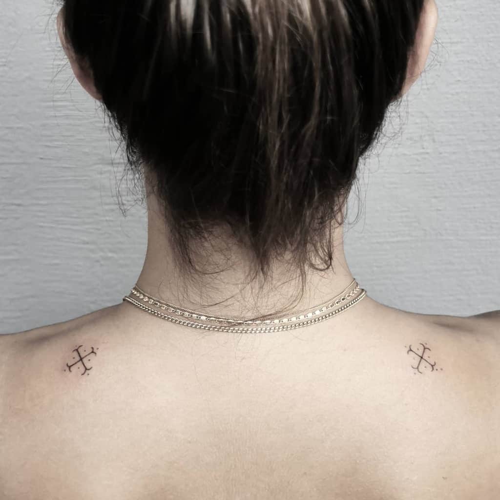 Cross tattoo on each shoulder