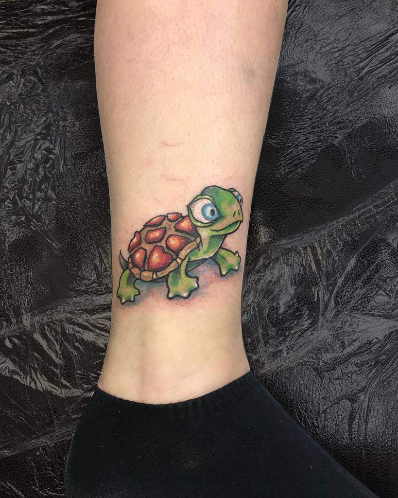 Colorful turtle tattoo on a leg above an ankle