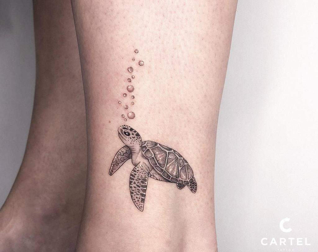 Tattoo of a sea turtle blowing bubbles on a leg