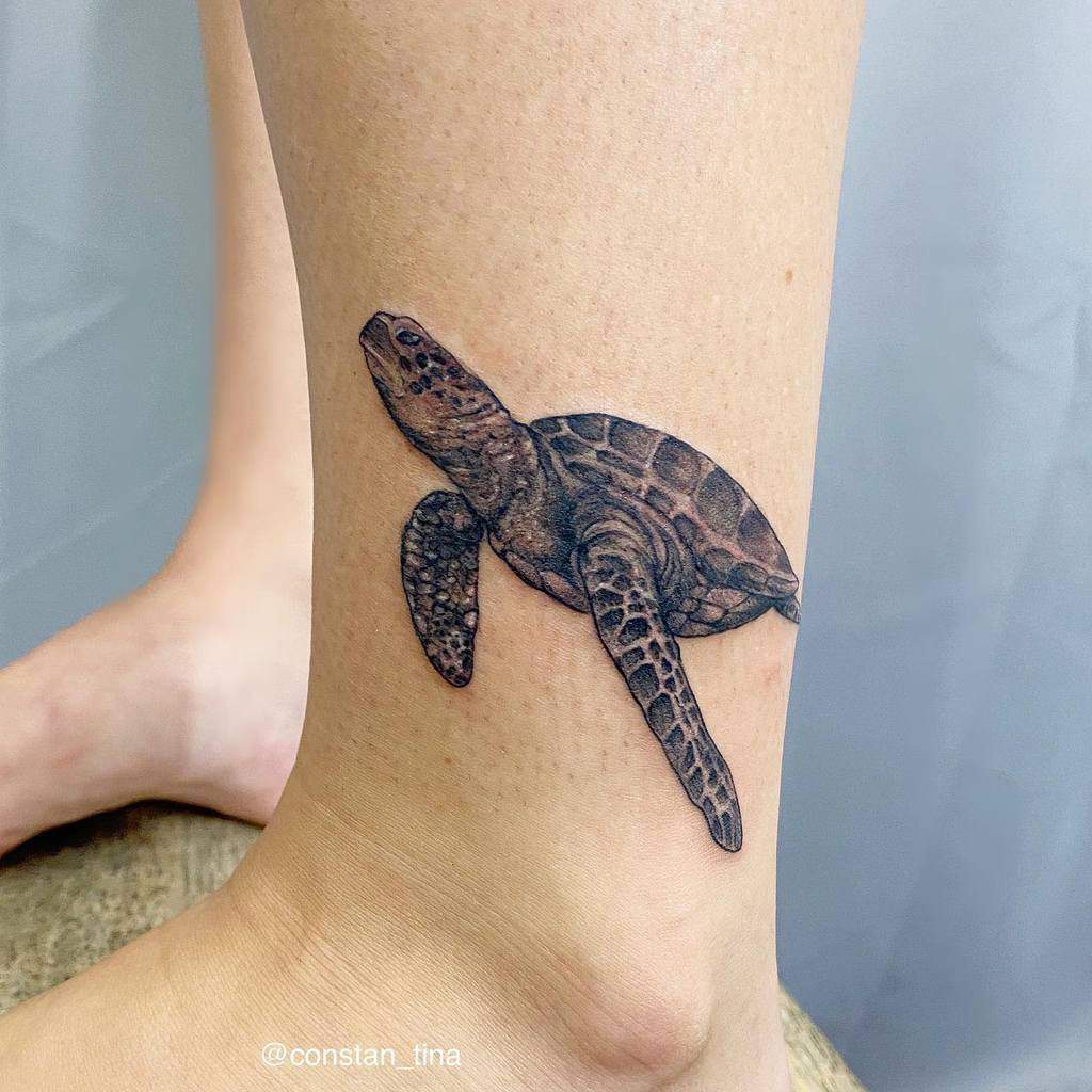 A realistic turtle tattoo on an ankle