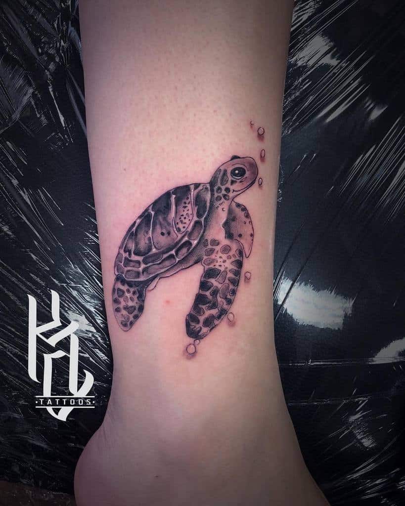 A detailed sea turtle tattoo on an ankle
