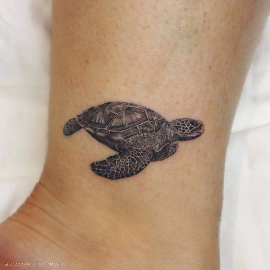 A realistic sea turtle tattoo on an ankle