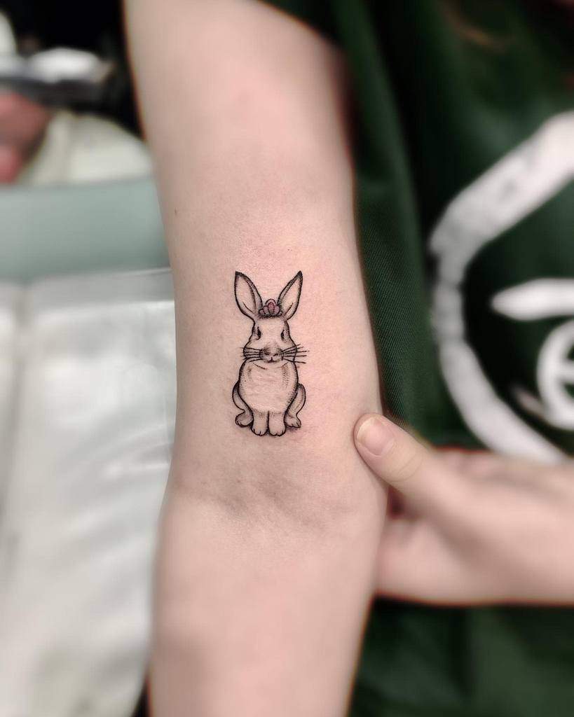 Tattoo of a small rabbit with a flower on its head