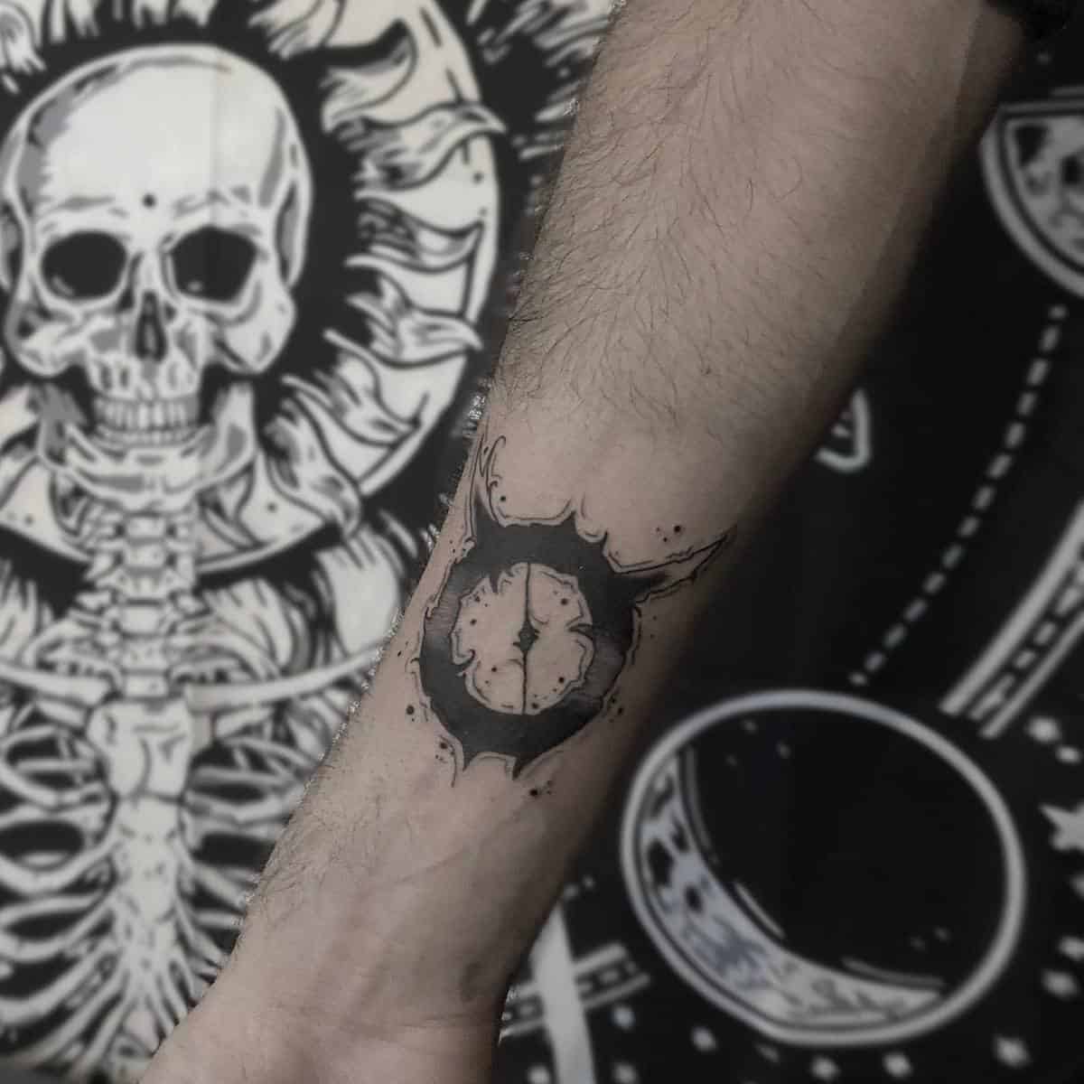 Forearm tattoo featuring a stylized black sun