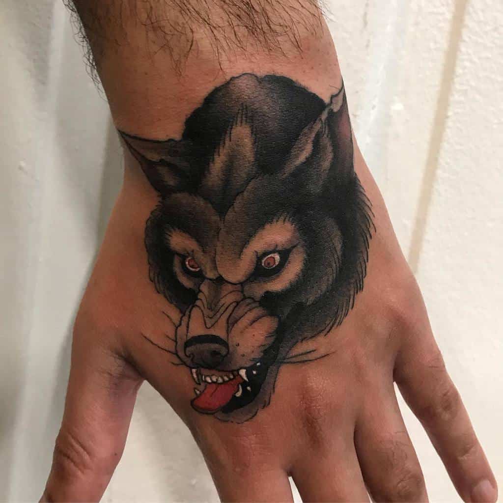 A fierce tattoo of a snarling wolf with piercing red eyes sprawls across the back of a hand