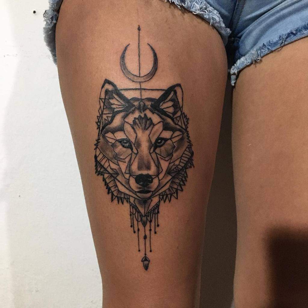 Geometric tattoo featuring a majestic wolf silhouetted by a crescent moon on the thigh
