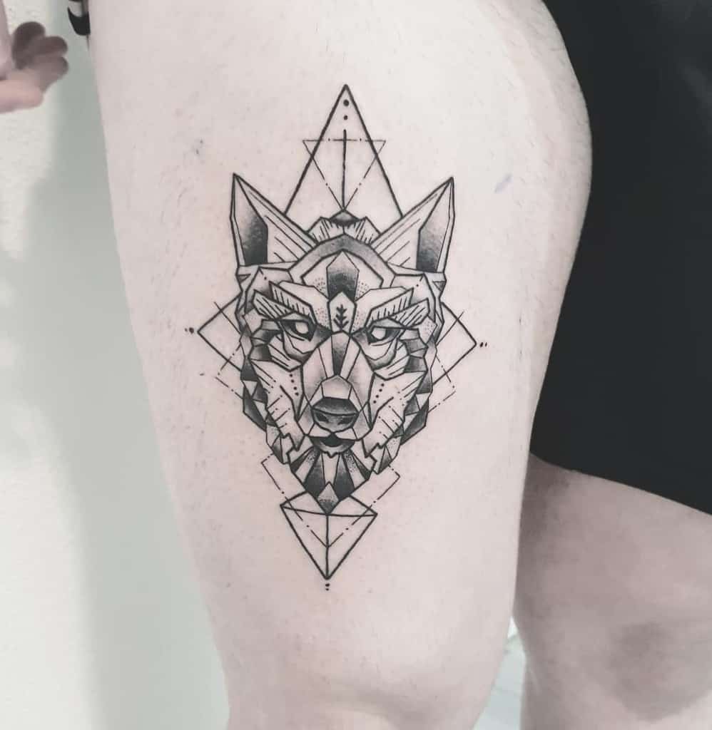 A stunning geometric design of a wolf inked exquisitely on a thigh