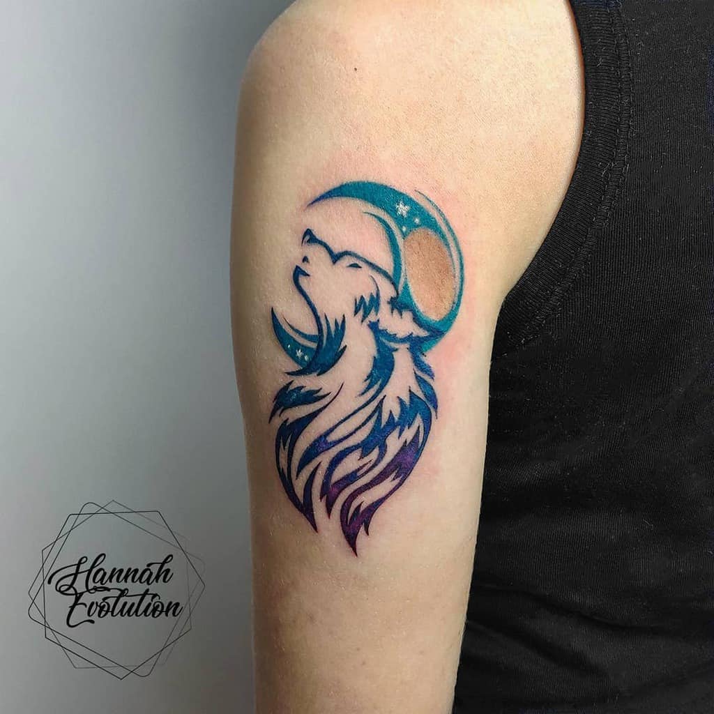 A mesmerizing tattoo featuring a majestic wolf beneath a crescent moon adorns the person's upper arm