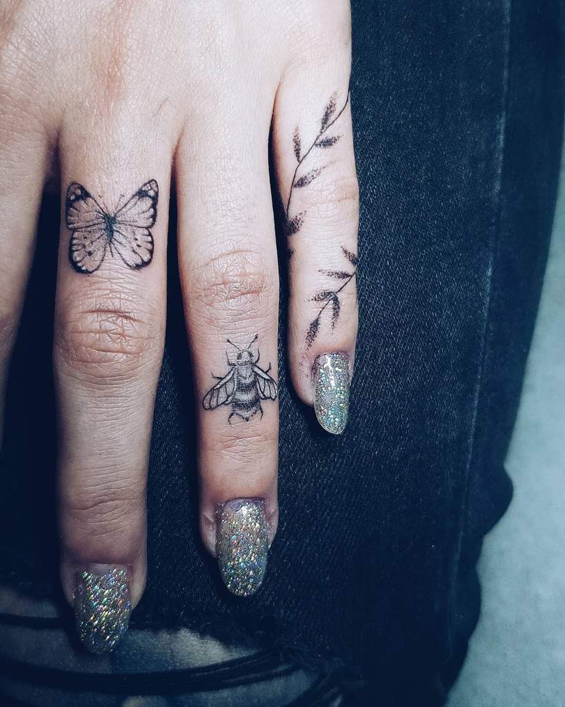 Hand with butterfly, bee, leaf tattoos