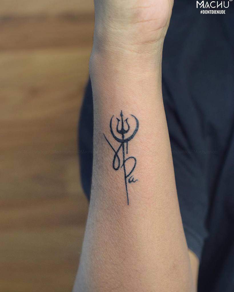 Tattoo of a trident symbol with intricate lines on a wrist