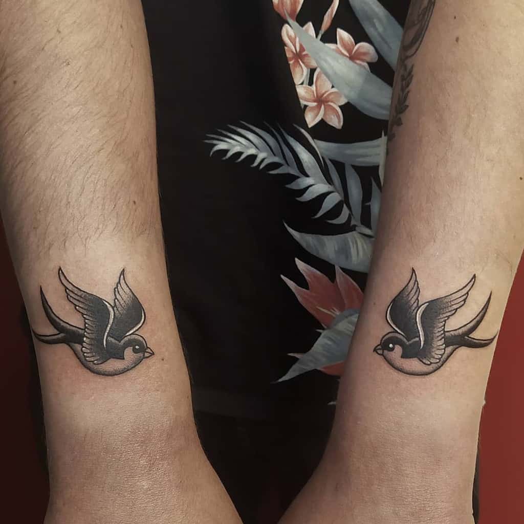 Matching swallow tattoos on two wrists