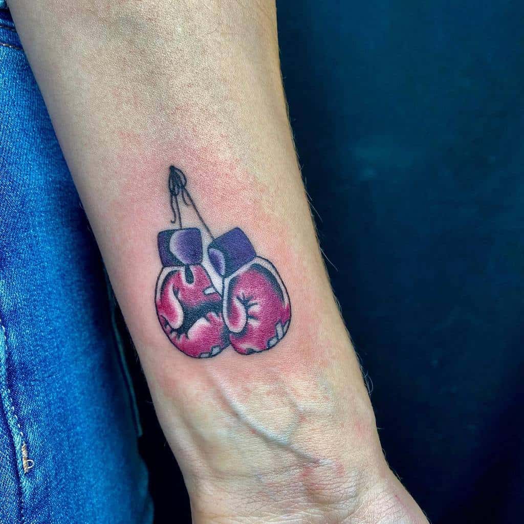 Tattoo of purple boxing gloves hanging on a wrist