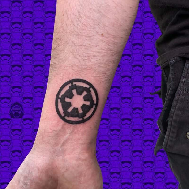 Tattoo of a black emblem on a wrist