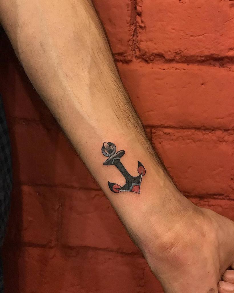 Tattoo of a stylized anchor on a person's wrist with a red and black design