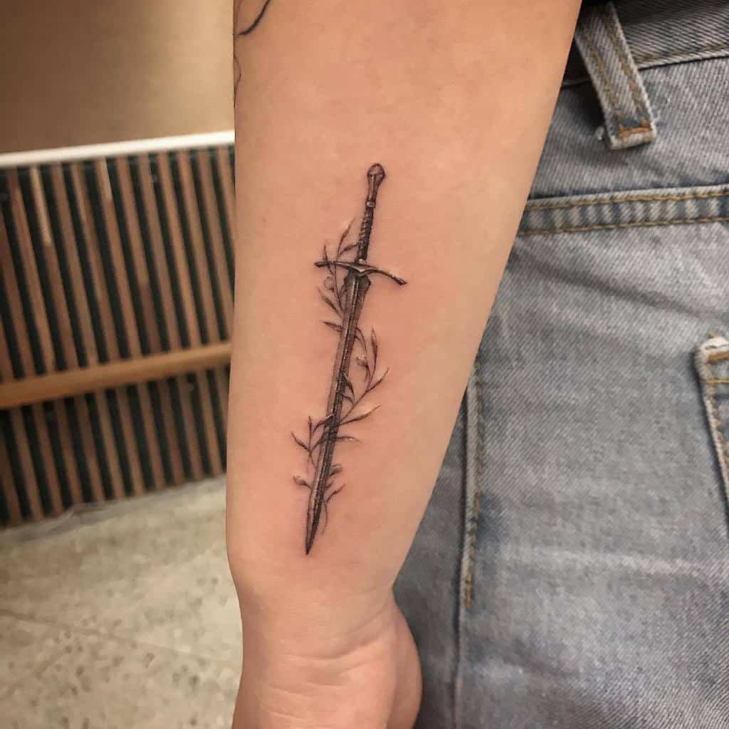 A tattoo of a sword with leafy vines wraps around a wrist