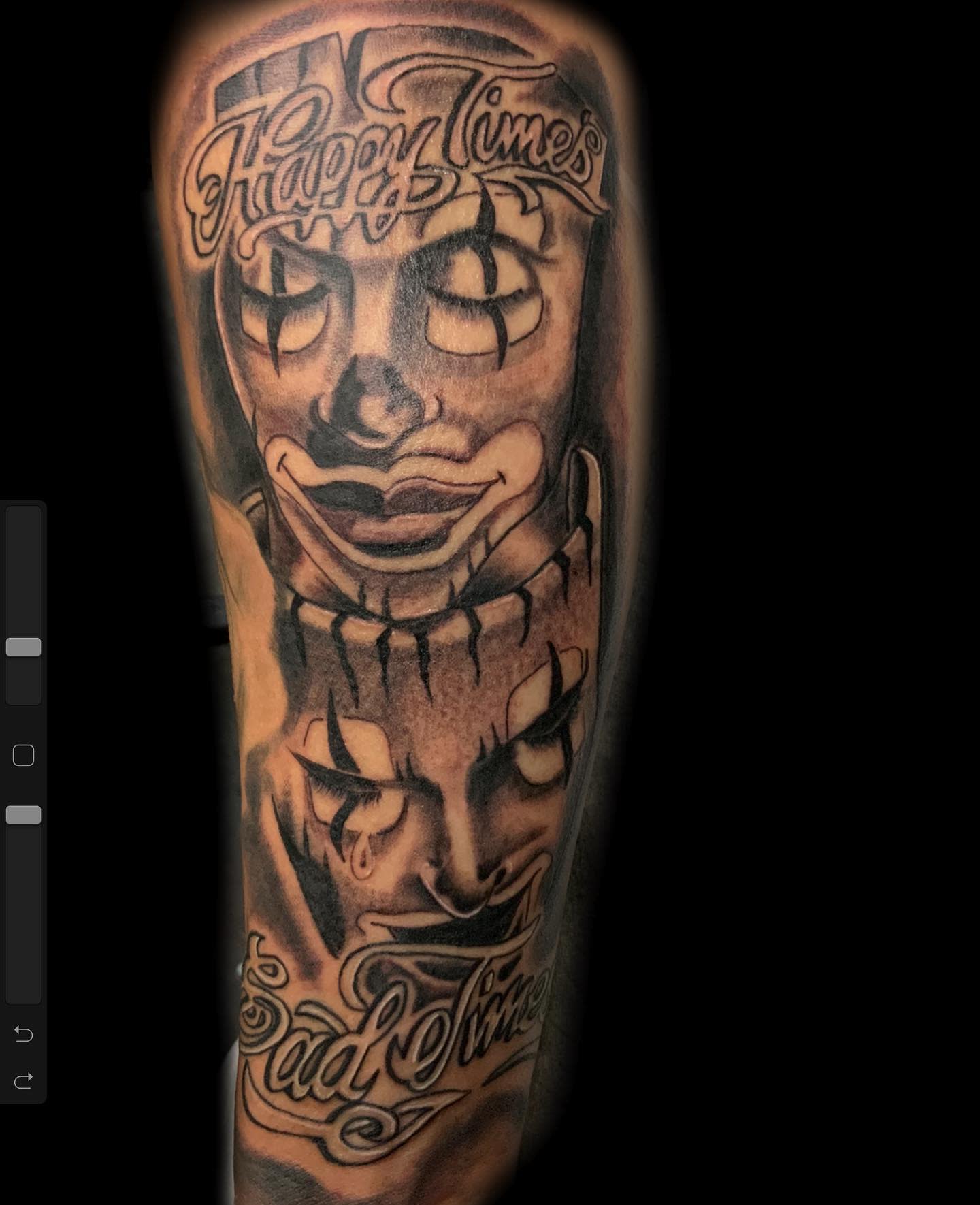 Tattoo of two masks: one smiling with "Happy Times," one crying with "Sad Times"