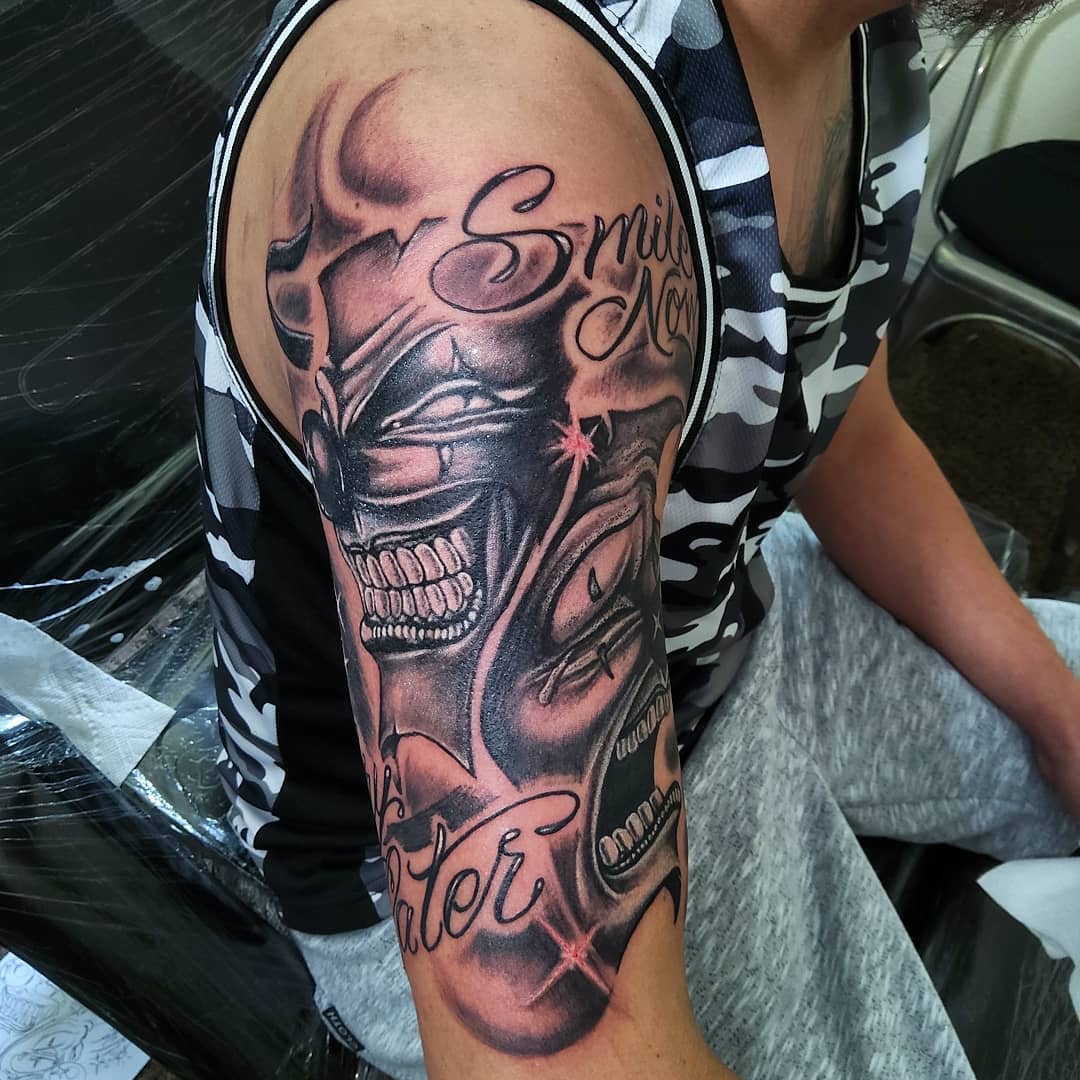 Tattoo of grinning faces on their upper arm