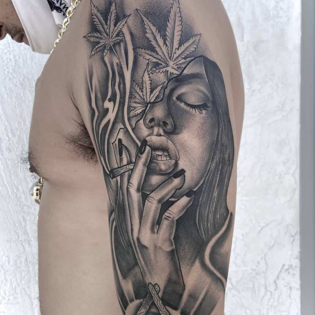 Tattoo of a woman smoking, surrounded by cannabis leaves and smoke, in detailed black and grey shading on the upper arm