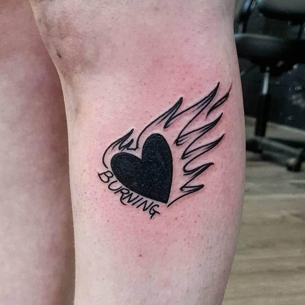 Solid black heart tattoo with bold flame design and the word 'BURNING' beneath it