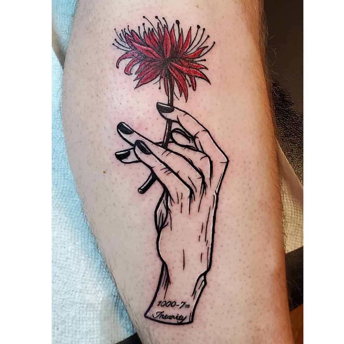 Leg tattoo featuring a hand holding a red spider lily, symbolizing death and rebirth, with intricate linework and subtle shading