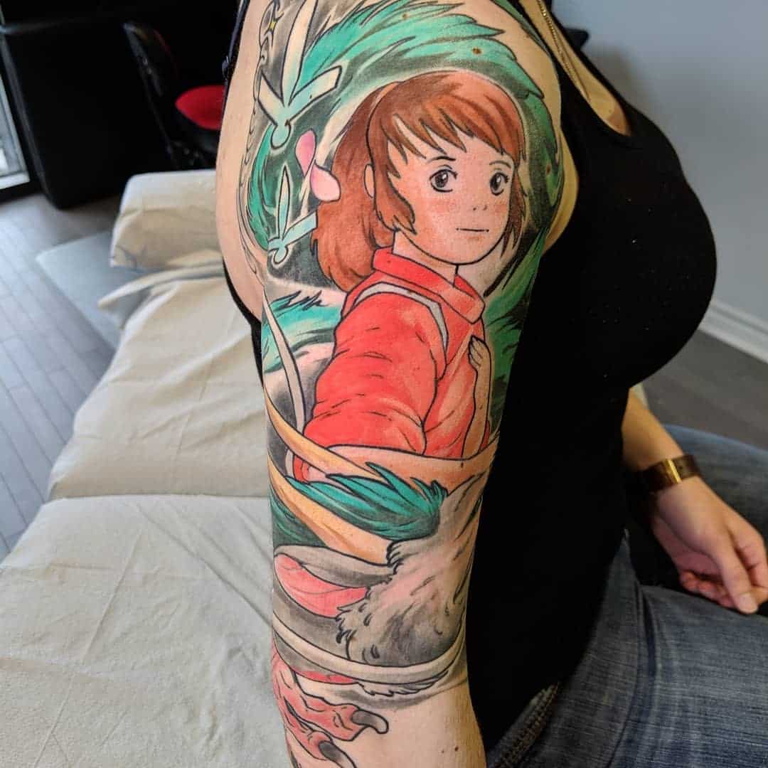Vibrant tattoo of Chihiro with Haku in his dragon form from Spirited Away on the upper arm