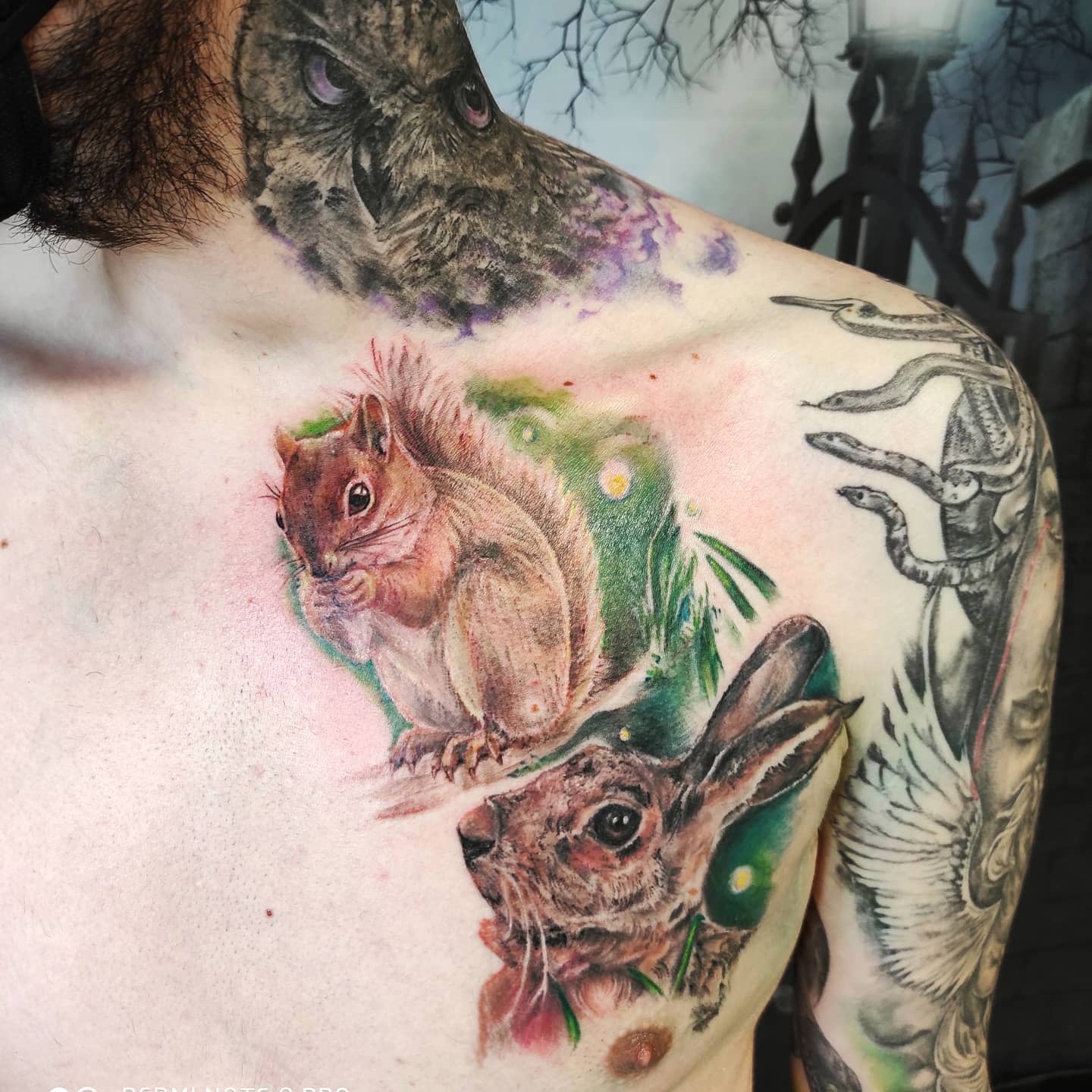 Colorful squirrel and rabbit tattoos on a chest, with other shaded tattoos nearby