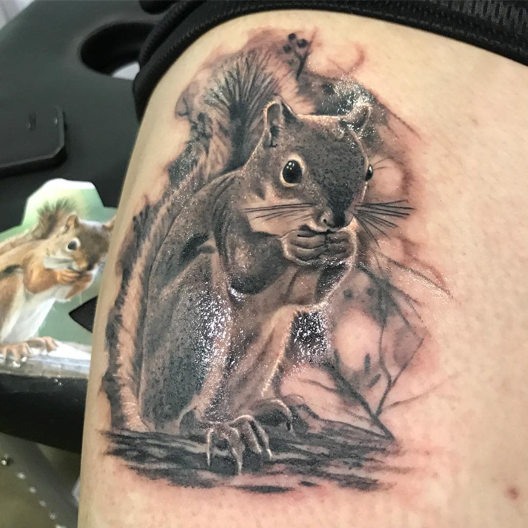 Tattoo of a realistic squirrel eating inked on skin