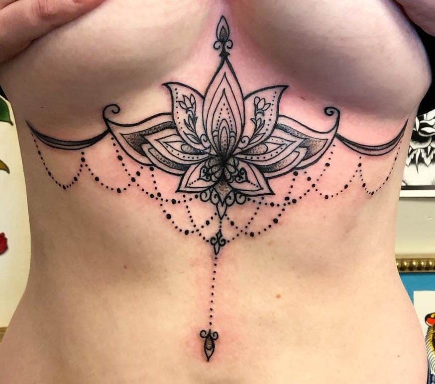 Floral mandala chest chandelier tattoo with intricate lines and dotted chain patterns 