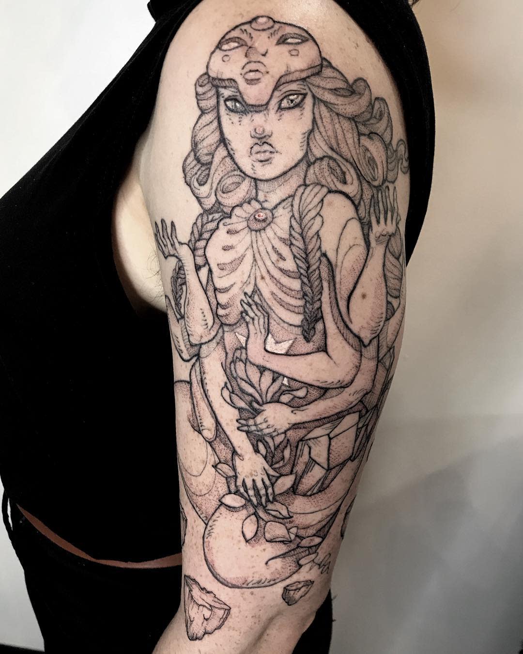 Intricate black ink tattoo on the arm featuring a stylized depiction of a fusion from Steven Universe