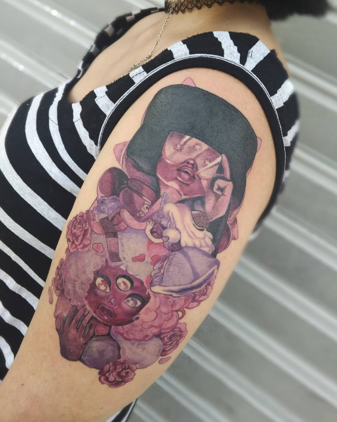 Detailed tattoo of Garnet from Steven Universe, featuring her three-eyed design, with a mix of vibrant colors and roses, on the upper arm
